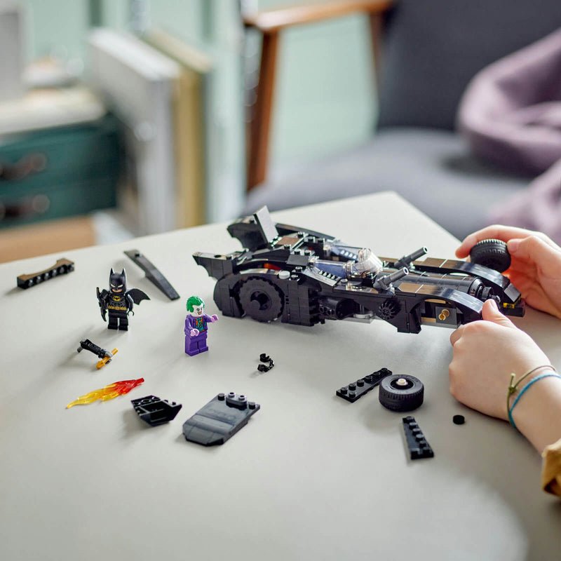child building a lego batmobile