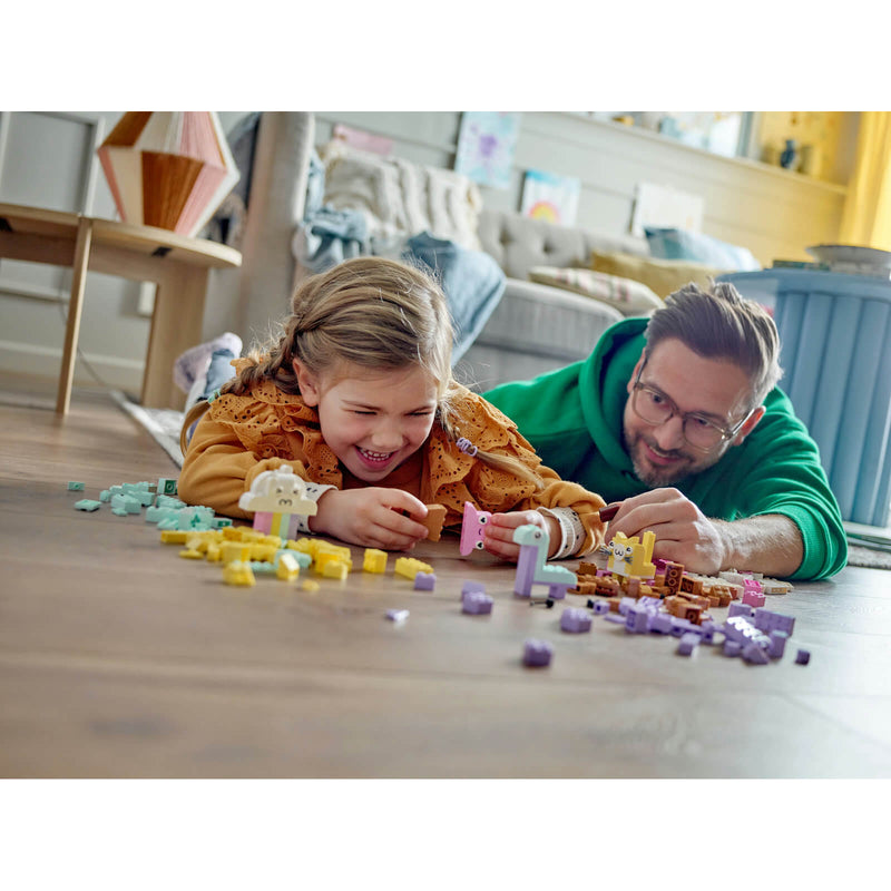 man and child playing with pastel lego brick set