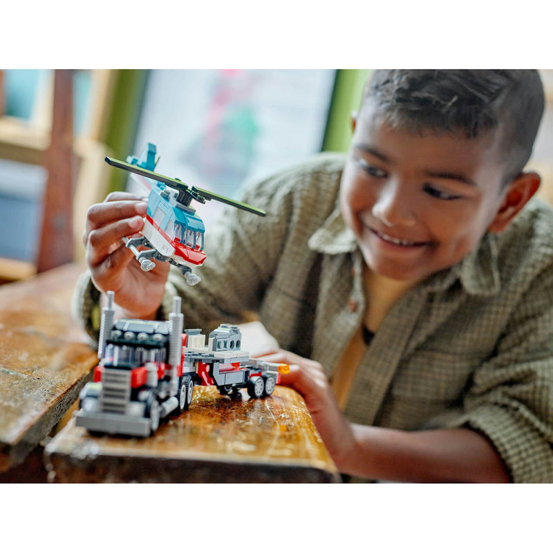 Child playing with Lego helicopter and truck